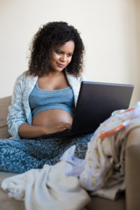 pregnant person using laptop computer